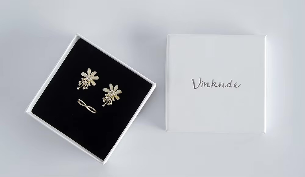 White minimalist packaging with earrings and ring